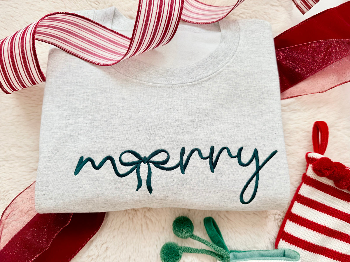Our Merry Bow Embroidered Sweater is the perfect mix of cozy and Christmas charm! Featuring a beautiful handwritten-style "merry" design with a delicate bow incorporated into the lettering, this minimalist Christmas crewneck is a timeless addition to your holiday wardrobe.