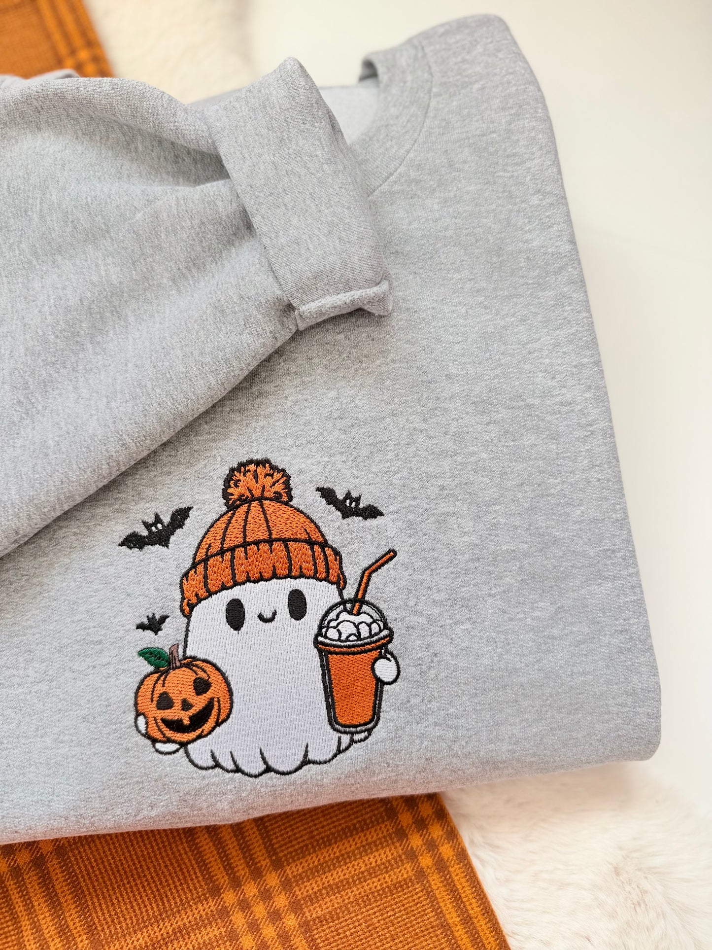 Meet the ultimate autumn mood: a cute embroidered ghost rocking a cozy orange toque, clutching an iced pumpkin spice coffee and a classic jack-o'-lantern. Designed with dense, high-quality embroidery for long-lasting wear, this cozy heather grey crewneck is the perfect mix of trendy and nostalgic for everyday spooky season style.