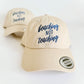 Beige cap with 'beaching not teaching' text on a white background. Embroidered custom hat stitched in Ontario, Canada. 