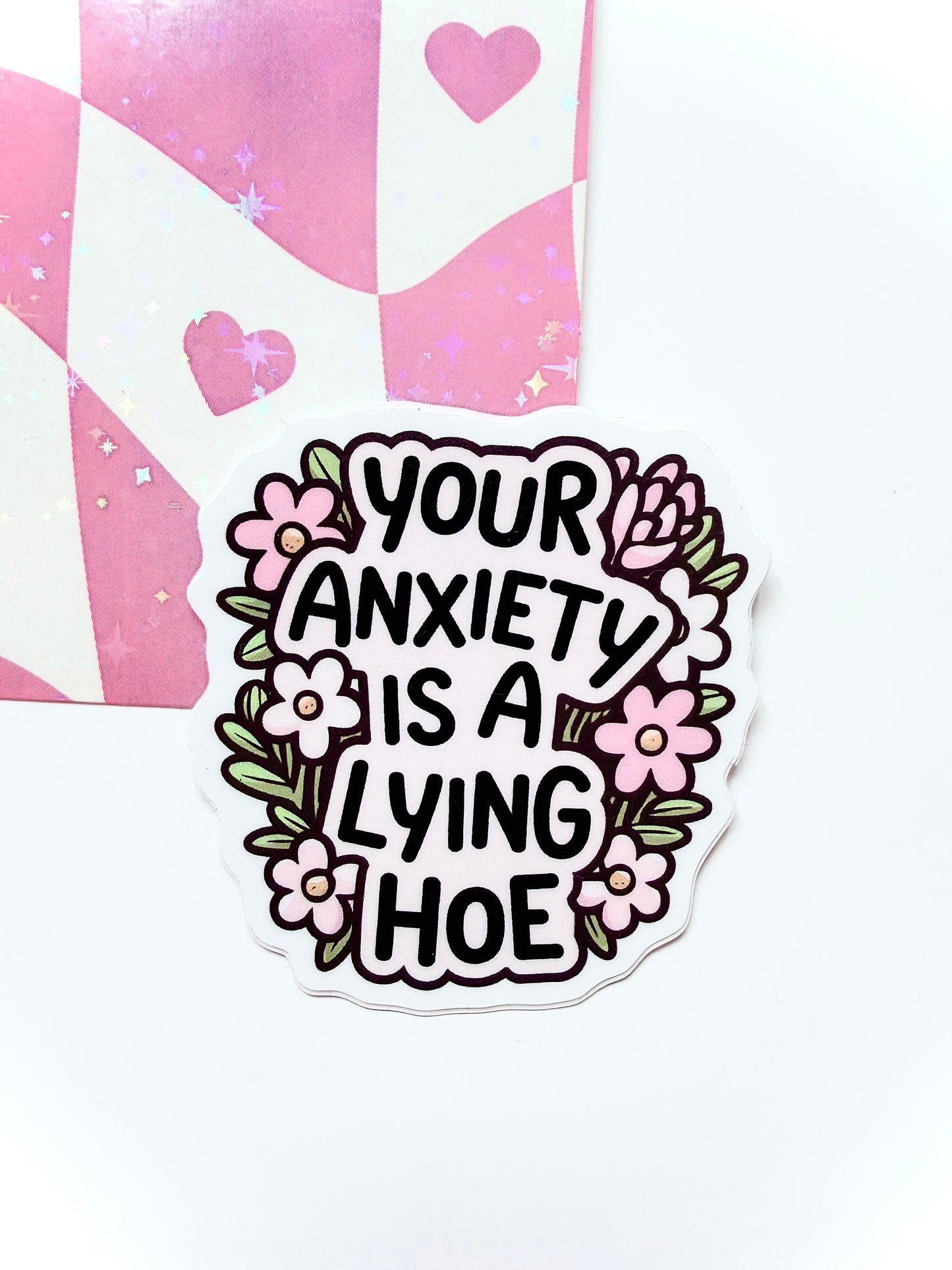 Sticker with text 'Your anxiety is a lying hoe' surrounded by floral designs on a white background.