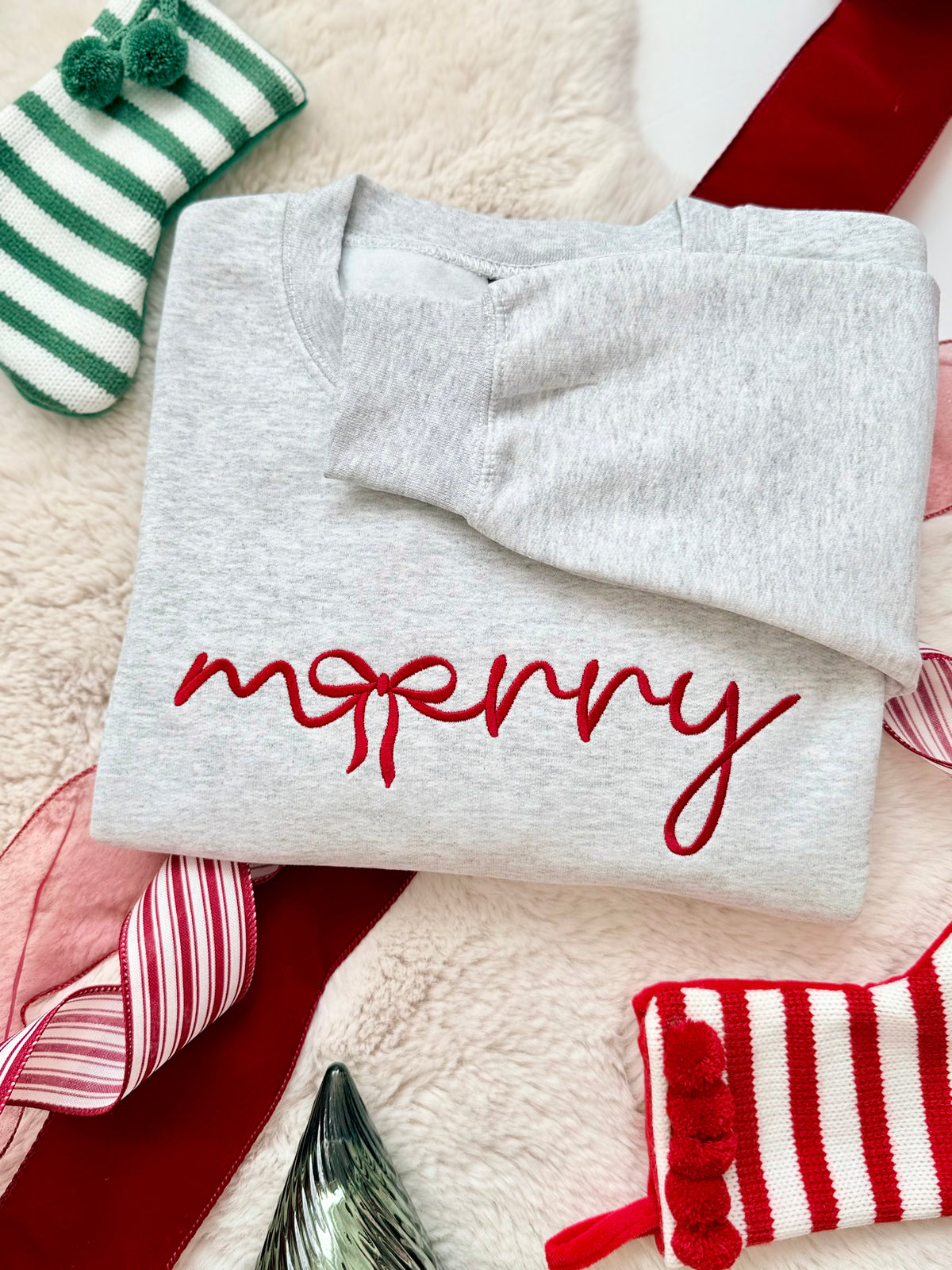 Our Merry Bow Embroidered Sweater is the perfect mix of cozy and Christmas charm! Featuring a beautiful handwritten-style "merry" design with a delicate bow incorporated into the lettering, this minimalist Christmas crewneck is a timeless addition to your holiday wardrobe.
