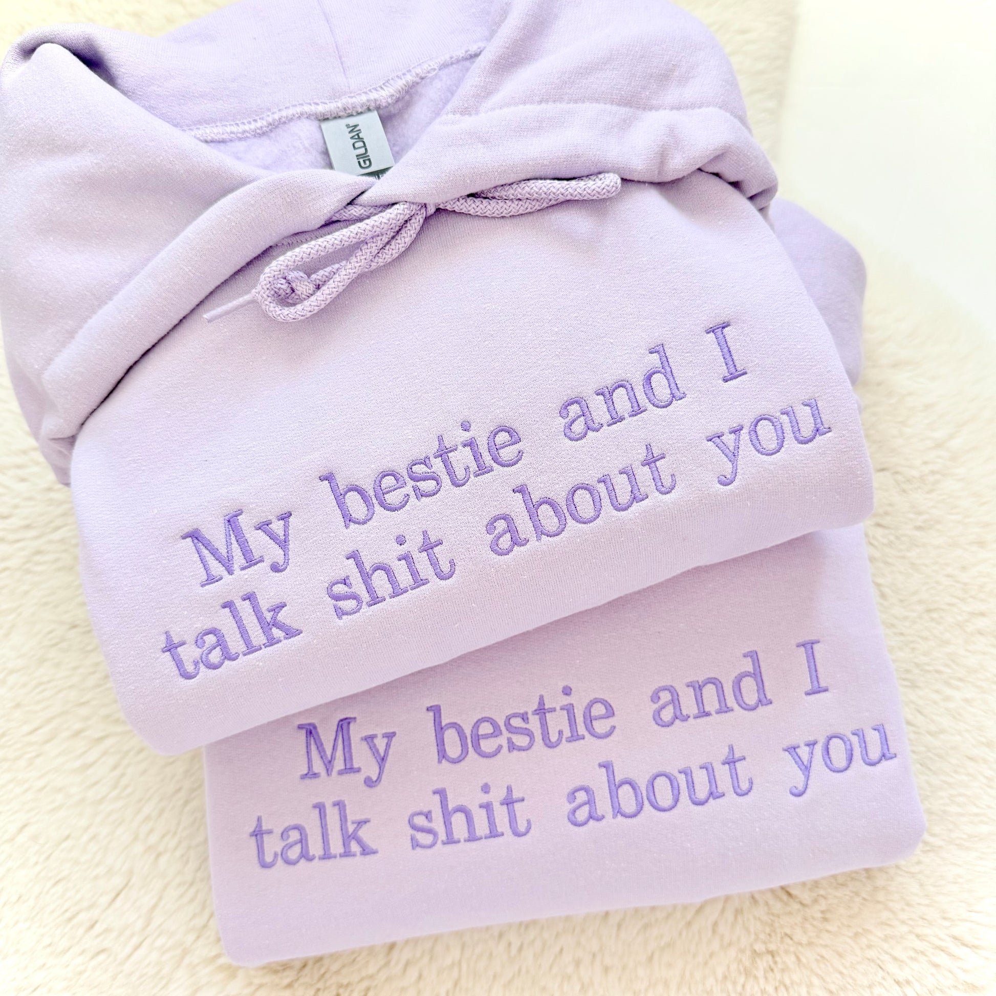 Light purple hoodie with embroidered text on a light background