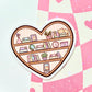 Heart-shaped bookshelf sticker on a pink and white checkered background