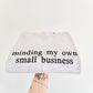 light ash grey crewneck with 'minding my own small business' text embroidered on it, displayed on a white background.