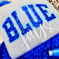 Gray sweater with blue glittery text and white cursive text on a blue textured background. Blue Jays fanwear.