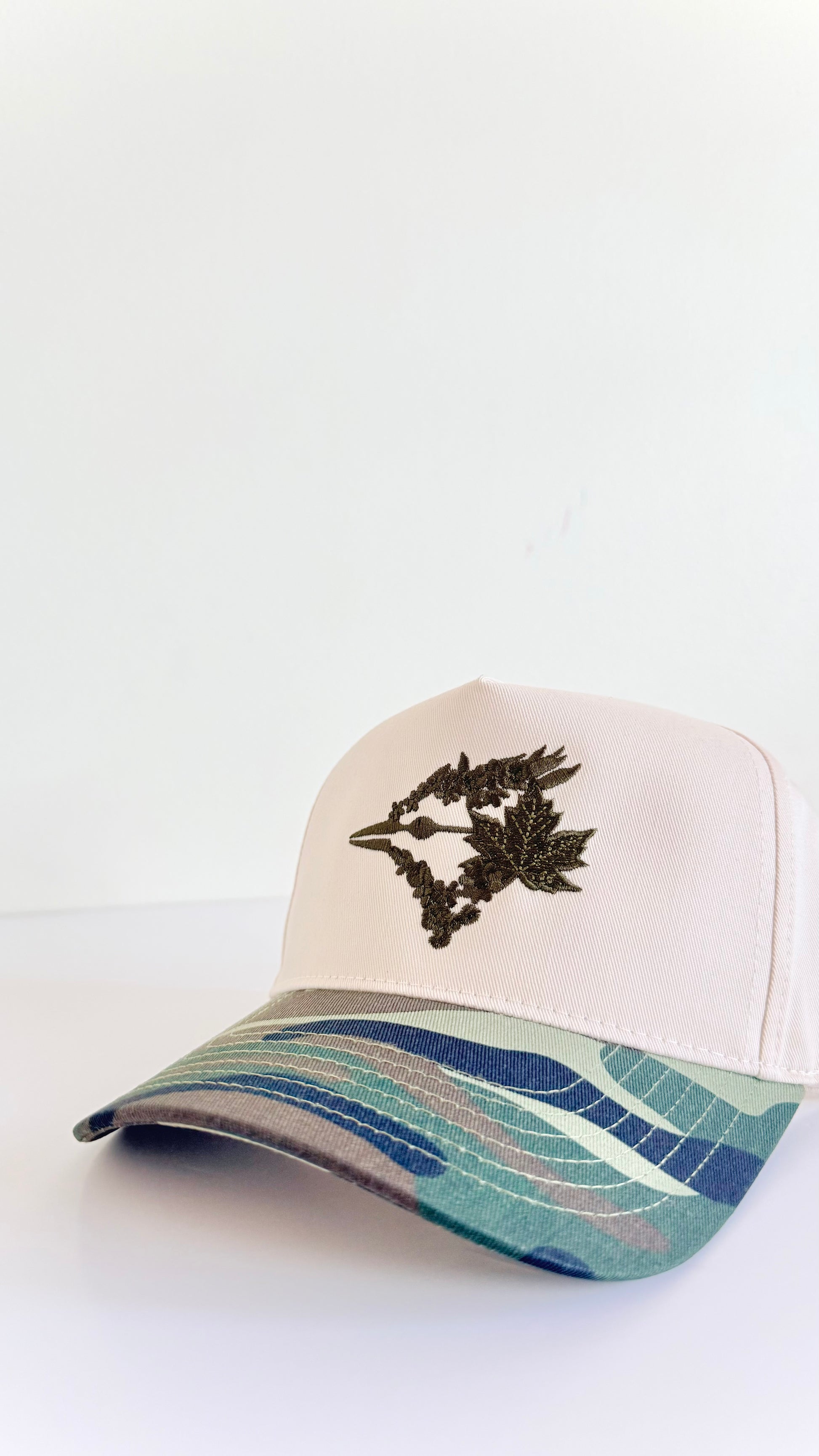 Trucker hat with floral design and wavy pattern on a white background camo