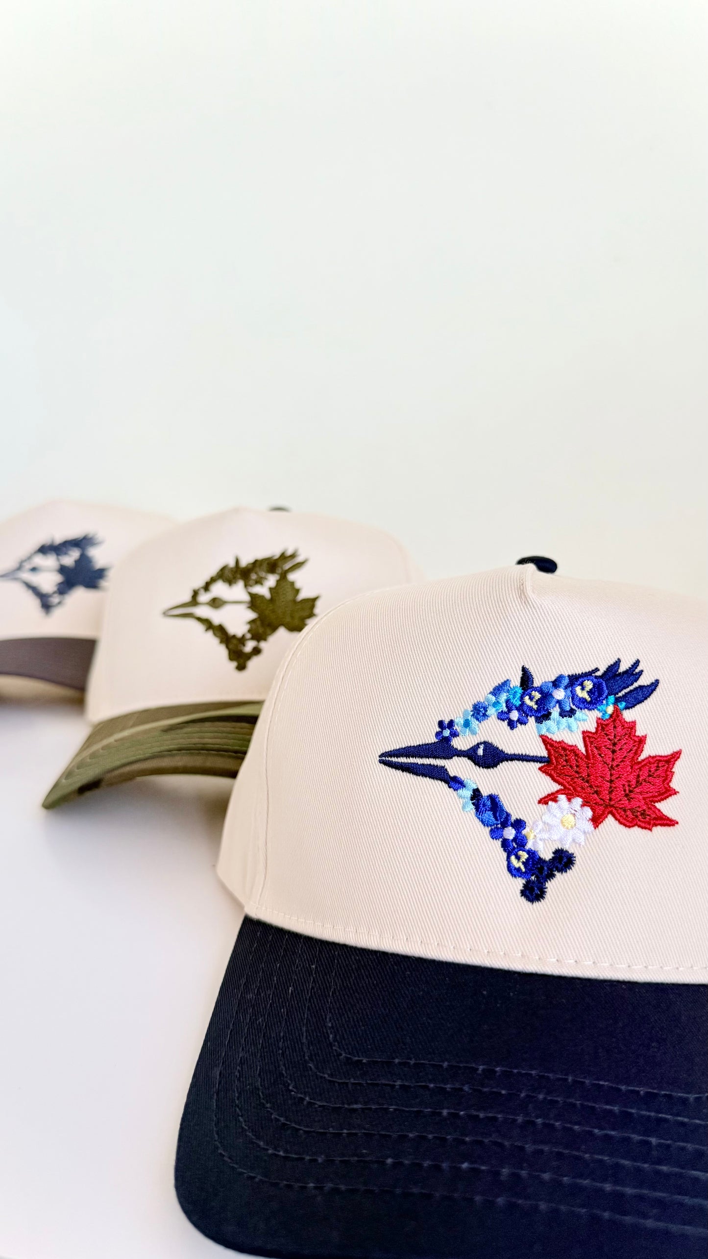Baseball caps with embroidered designs on a white background