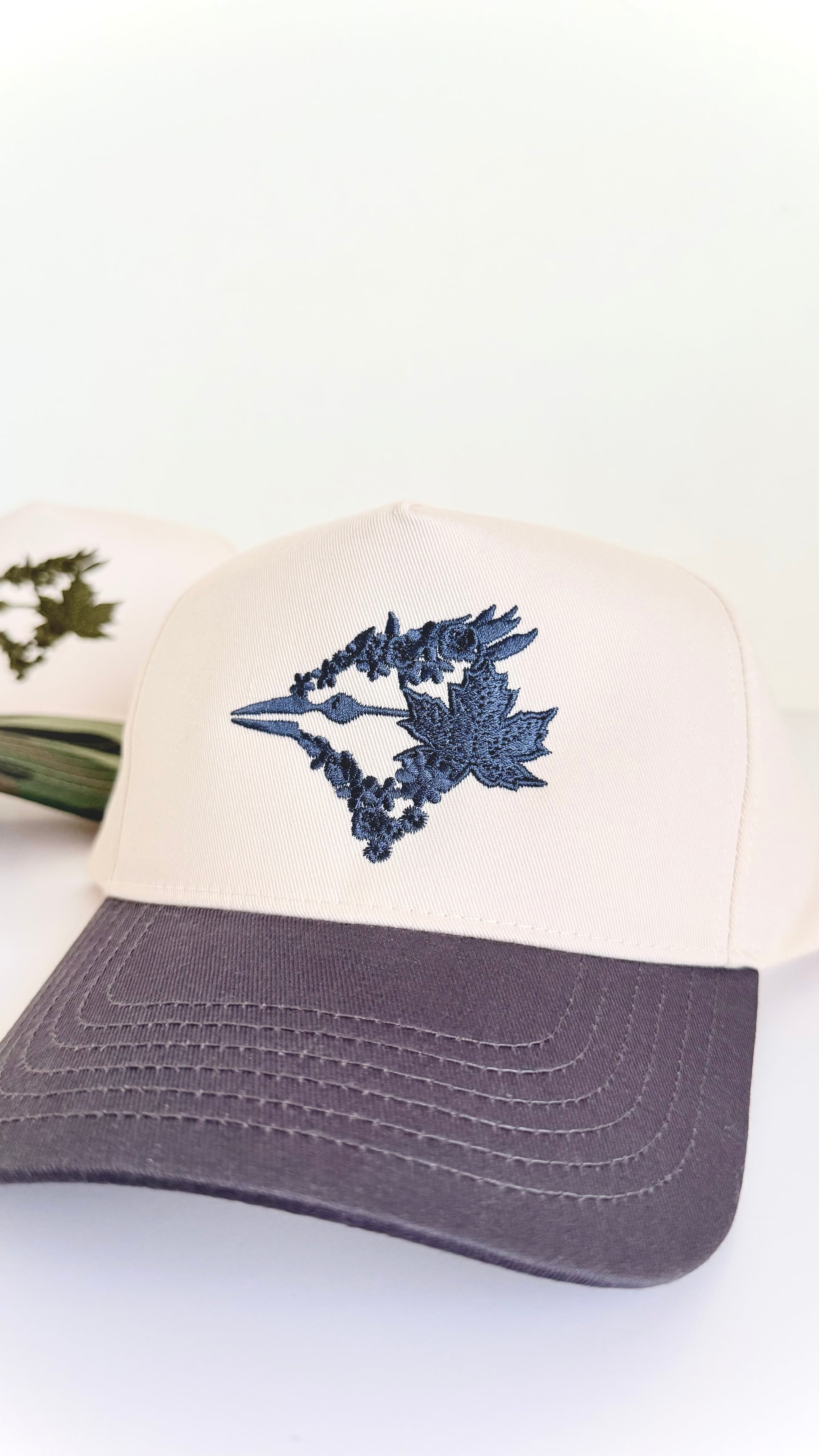 Cap with blue floral design on a white background charcoal grey