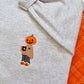 Gourd girl embroidered fall autumn sweater. Pumpkin head girl holding a coffee wearing a cozy sweater wearing pajama pants stitched onto a light grey sweater.