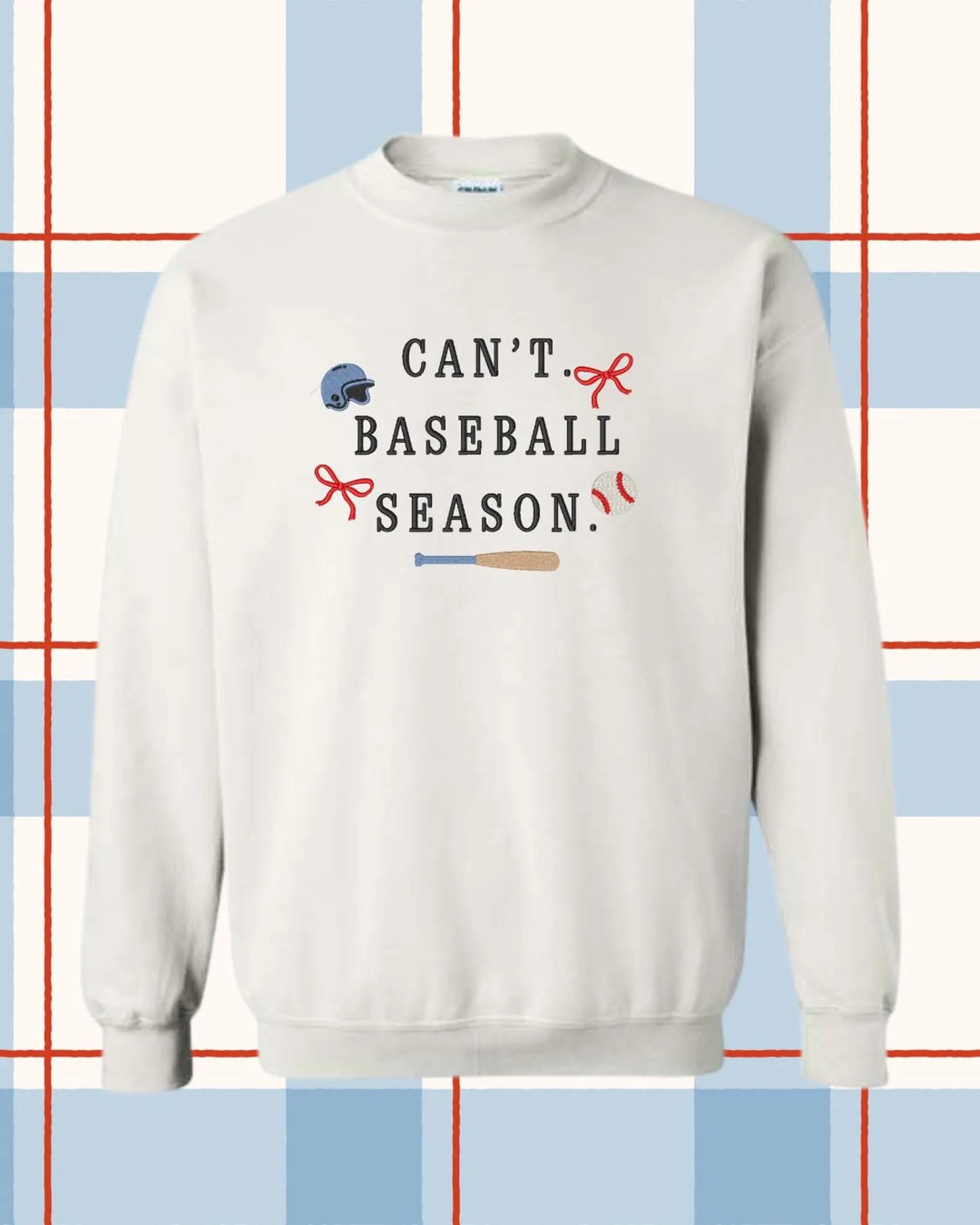 White sweatshirt with 'Can't. Baseball Season.' text on a blue and red grid background. embroidered baseball mama apparel. Game Day Fashion for Canadian Moms.